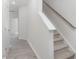Hallway and carpeted stairs with white walls and grey laminate floors at 1916 Frost Dr, Haw River, NC 27258