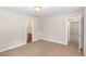 Neutral bedroom with beige walls and carpet, plus access to a private bathroom at 2623 Broad Oaks Pl, Raleigh, NC 27603