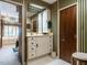 Bathroom featuring striped wallpaper, white vanity with ample storage, and a large soaking tub at 3206 Sussex Rd, Raleigh, NC 27607