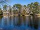 Scenic lake with a wooden bridge surrounded by lush trees and foliage, creating a picturesque view at 3206 Sussex Rd, Raleigh, NC 27607