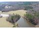 Majestic aerial view featuring a peaceful pond nestled within expansive pastoral land at 3344 Cobb Farm Trl, Mebane, NC 27302