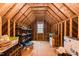 Unfinished attic with exposed beams, small window and storage at 3344 Cobb Farm Trl, Mebane, NC 27302