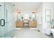 Well-lit bathroom with dual vanities, a glass-enclosed shower, and neutral tile flooring at 3344 Cobb Farm Trl, Mebane, NC 27302