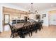 Open-concept dining room featuring a long wooden table with seating for ten, a jute rug, and bright natural light at 3344 Cobb Farm Trl, Mebane, NC 27302