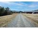 Long gravel driveway leading to a house and a barn, offering privacy and space at 3344 Cobb Farm Trl, Mebane, NC 27302