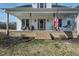 Inviting front porch with seating and a swing, perfect for relaxing, and an American flag displayed at 3344 Cobb Farm Trl, Mebane, NC 27302