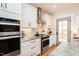 Close up of modern kitchen featuring stainless steel appliances, granite countertops and white cabinets with black hardware at 3344 Cobb Farm Trl, Mebane, NC 27302