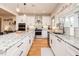 Well-lit kitchen boasts white cabinets, granite countertops, stainless steel appliances, and hardwood flooring at 3344 Cobb Farm Trl, Mebane, NC 27302