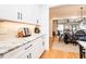 Open concept kitchen with white cabinets, granite countertops, and hardwood floors opens to the dining area and living room at 3344 Cobb Farm Trl, Mebane, NC 27302