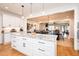 Open concept: Kitchen overlooking dining and living areas, featuring white cabinets, granite countertops, and hardwood floors at 3344 Cobb Farm Trl, Mebane, NC 27302