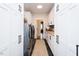 A well-organized laundry room with white cabinets, butcher block countertops, and black tile floors at 3344 Cobb Farm Trl, Mebane, NC 27302