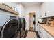 A laundry room with white cabinets, butcher block countertops and gray front load washer and dryer at 3344 Cobb Farm Trl, Mebane, NC 27302