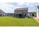 Backyard view of the lush lawn, screened in porch, and home's exterior, offering peaceful outdoor enjoyment at 3521 Amelia Grace Dr # 67, Fuquay Varina, NC 27526