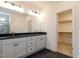 Bathroom featuring dual sinks, a granite countertop, black floors, and a walk-in closet at 3521 Amelia Grace Dr # 67, Fuquay Varina, NC 27526