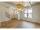 Bright dining room with hardwood floors, stylish light fixture, and natural light through the large window at 3521 Amelia Grace Dr # 67, Fuquay Varina, NC 27526