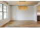 Open dining room with wood floors, elegant lighting, and a seamless flow to the kitchen at 3521 Amelia Grace Dr # 67, Fuquay Varina, NC 27526