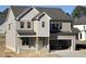Exterior view of a new construction home with neutral toned siding, a two-car garage, and covered porch at 3521 Amelia Grace Dr # 67, Fuquay Varina, NC 27526