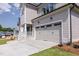 Close-up of a two-car garage featuring carriage doors and exterior lighting at 3521 Amelia Grace Dr # 67, Fuquay Varina, NC 27526