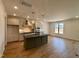 Bright kitchen featuring modern cabinets, an island with pendant lights, and wood floors at 3521 Amelia Grace Dr # 67, Fuquay Varina, NC 27526