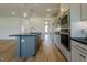 Modern kitchen featuring stainless steel appliances, a gray island with sink, and hardwood floors at 3521 Amelia Grace Dr # 67, Fuquay Varina, NC 27526