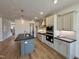 Modern kitchen featuring new stainless appliances, an island, hardwood floors, and gray cabinets at 3521 Amelia Grace Dr # 67, Fuquay Varina, NC 27526