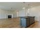 Open concept living space featuring a kitchen island, fireplace, and hardwood floors at 3521 Amelia Grace Dr # 67, Fuquay Varina, NC 27526