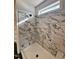 Shower with grey marble tiling, shower head, and window at 3521 Amelia Grace Dr # 67, Fuquay Varina, NC 27526