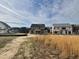 View of homes under construction, with a field of high grass in the foreground, under a blue sky with patchy clouds at 3521 Amelia Grace Dr # 67, Fuquay Varina, NC 27526