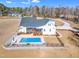 An aerial view reveals a sparkling blue pool and lovely landscaped grounds at 3608 Buzzard Rd, Wendell, NC 27591