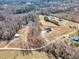 Aerial view of a private home surrounded by wooded acreage, a serene pond, and outbuildings on the property at 3608 Buzzard Rd, Wendell, NC 27591