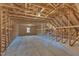 Spacious unfinished attic featuring exposed wood beams and a window offering natural light at 3608 Buzzard Rd, Wendell, NC 27591