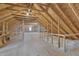 Large attic with exposed wooden rafters and beams, featuring a partial subfloor and insulation at 3608 Buzzard Rd, Wendell, NC 27591