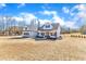 Charming white farmhouse with an inviting covered porch, neat landscaping, and spacious front lawn on a sunny day at 3608 Buzzard Rd, Wendell, NC 27591