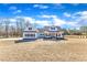 Beautiful white farmhouse exterior, featuring a covered porch, dark shutters, and a spacious well-manicured front lawn at 3608 Buzzard Rd, Wendell, NC 27591