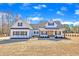 Charming farmhouse exterior with a covered front porch, white siding, black shutters, and a well-manicured lawn at 3608 Buzzard Rd, Wendell, NC 27591