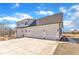 Three-car garage with a long concrete driveway, and trimmed lawn, showcasing ample parking and outdoor space at 3608 Buzzard Rd, Wendell, NC 27591