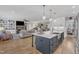 Open-concept kitchen featuring an island, stainless steel appliances, and view into a living room with fireplace at 3608 Buzzard Rd, Wendell, NC 27591