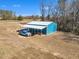 An aerial shot showcases a practical outbuilding with vehicle parking surrounded by beautiful trees at 3608 Buzzard Rd, Wendell, NC 27591