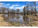 Scenic view of a tranquil pond surrounded by trees, reflecting the sky in its calm waters at 3608 Buzzard Rd, Wendell, NC 27591