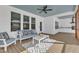 Inviting screened porch with a blue ceiling, comfortable seating, and an outdoor ceiling fan at 3608 Buzzard Rd, Wendell, NC 27591