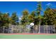 Outdoor basketball court fenced in and surrounded by mature trees creates a private recreational space at 365 Shawnee Dr, Louisburg, NC 27549