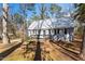 Charming cottage-style home featuring a metal roof, black shutters, and inviting front porch at 365 Shawnee Dr, Louisburg, NC 27549