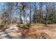 Secluded cottage-style home with a metal roof surrounded by lush trees on a sprawling lot at 365 Shawnee Dr, Louisburg, NC 27549