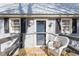 Inviting cottage front porch with welcome decor, wicker chair, and views of the home's exterior at 365 Shawnee Dr, Louisburg, NC 27549