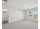 Bright bedroom with neutral carpet and walls featuring two windows and ensuite bathroom access at 3725 Rosebush Dr, Zebulon, NC 27597