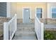Inviting covered front porch with brick accents and steps leading to the light blue front door at 3725 Rosebush Dr, Zebulon, NC 27597