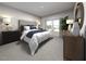 Serene main bedroom features a tufted headboard, stylish lamps, and natural light from the window at 3725 Rosebush Dr, Zebulon, NC 27597