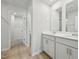 Bright bathroom featuring double sinks, white cabinets, and a doorway to a closet at 3727 Rosebush Dr, Zebulon, NC 27597