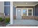 Inviting covered front porch with brick accents at 3727 Rosebush Dr, Zebulon, NC 27597