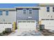 View of attached garages with two-car capacity featuring blue and gray siding at 3727 Rosebush Dr, Zebulon, NC 27597